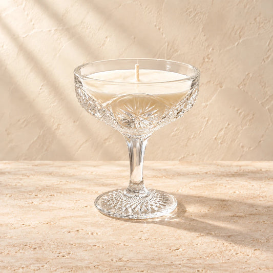 Petal | Vintage Cut Crystal Champagne Coupe candle styled on a warm ivory background